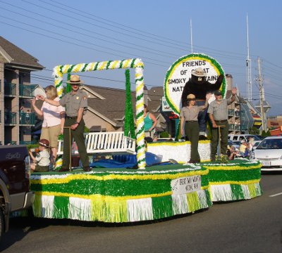 [Smoky the Bear and rangers on a green and yellow float.]